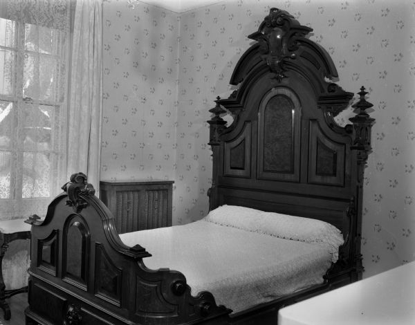 Interior view of the one of the bedrooms in the Wisconsin Governor's residence, 130 East Gilman Street. Shown is the ornate bed that Ole Bull, internationally famous violinist, brought to the home where he lived in the 1870s and 1880s. Bull came to the home to play when it was occupied by J.G. Thorp and his family. Bull subsequently married Thorps' daughter, Sara, and lived in the house until the time of his death.