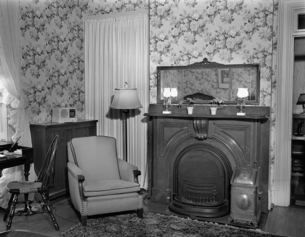 Interior view of the Wisconsin Governor's residence, 130 E. Gilman Street, showing a marble fireplace in one of the rooms, furnished with contemporary furniture, and possibly used as a study.