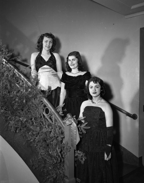 Three young woman singers in formal dresses standing on the staircase at the Madison Club, 5 East Wilson.  Taken for the <i>Wisconsin State Journal Youth</i> column.