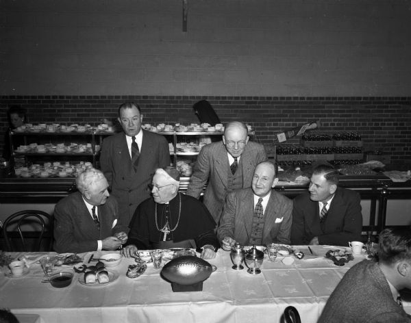 Dignitaries at the Edgewood High School football banquet.  Seated from the left are:  Leo Crowley, Bishop William P.O'Connor, Toastmaster Ed Owens, and an unidentified man.  Standing from the left are: John Roach, and Steve Slattery.