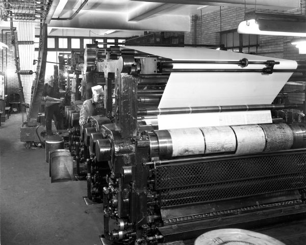<i>Wisconsin State Journal</i> employees in the press room with the printing presses.