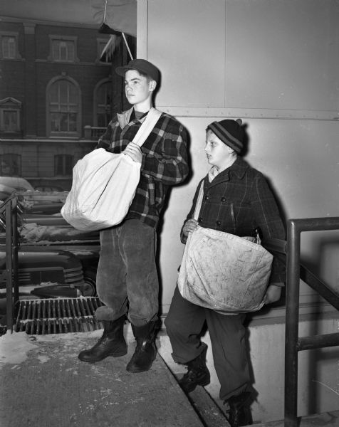 Two young paper carriers for the <i>Wisconsin State Journal</i> with their news bags.