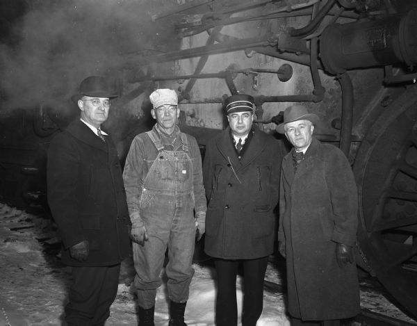 Charles Thiede, 2218 Rusk Street, is shown with his crew members before his last round-trip to Chicago. He is retiring after 41 years with the Chicago North Western Railroad.  Shown, left to right are W.B. Paulus, traveling engineer; Engineer Thiede; John Brody, conductor, Harvard, Illinois; and A.L. Eckles, train master.