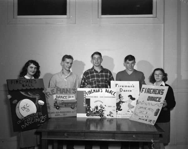 Madison Fireman's Ball poster contest winners with their posters. Shown from the left are: Sue Lentz, West High School; Jim Meier, East High School; Tom Allen, West High School; Bob Verberkmoes, East High School; Clarletta Kohl, Central High School, winner of the first prize.