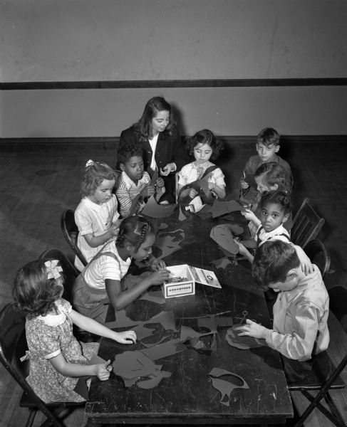 Children engaged in an art project at the Neighborhood House, 768 West Washington Avenue across from Brittingham Park. Pictured left to right are: Marion Derr, Sandra Dockey, Arlette Reddeman, Floyd Smith, instructor June Kelly, Sharon Landon. Denny Gerrasi. Rosemary Schmitz, Marilyn Mitchell, and John Caliva.
