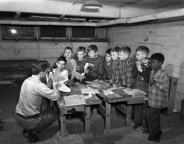 Children working with Paul Lowrey, instructor, at a small workbench at the Neighborhood House, 768 West Washington Avenue across from Brittingham Park. Pictured left to right: Paul Puccio, Ronald Pirten, Vicky Gervis, Dickey Genke, Peter Cerniglia, Robert Murphy, Thomas Philumalee, Billy Derr, and Albert Smith.