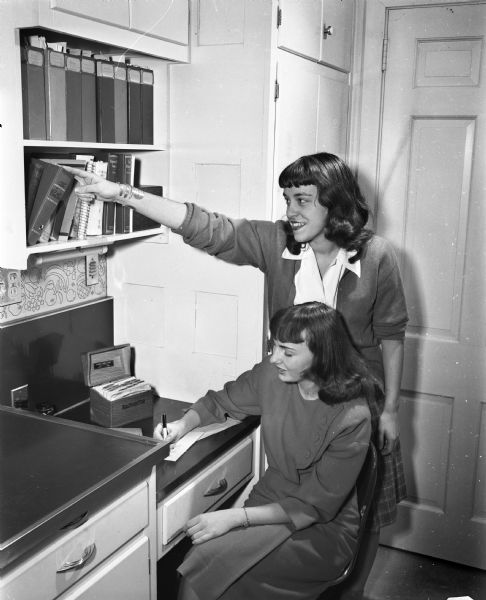 At work in the planning corner of the kitchen of the University of Wisconsin Home Management house, 1430 Linden Drive, are Jean Smith DeKalb, Illinois, seated, and Lura Zeirke, Hartland.