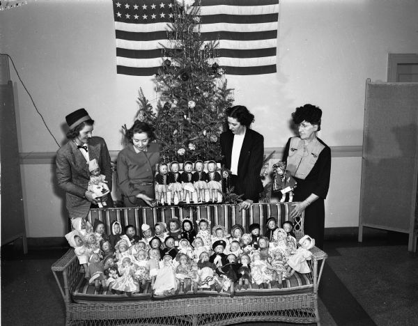 Madison Woman's Club members presenting 50 dolls to Orthopedic Hospital (Children's Hospital, a part of Wisconsin General Hospital). L to R: Mary E. Seybold, occupational therapist at Orthopedic Hospital; Elizabeth (Mrs. Keith) Parker; Cleo (Mrs. John C.) Sammis; Louise (Mrs. A.L.) Thurston.