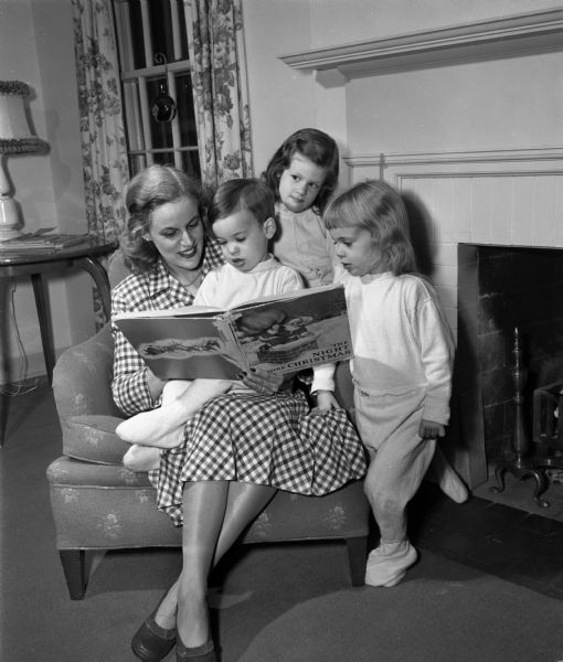 June McGovern is reading <i>The Night Before Christmas</i> to her children Diane, Jill and Jackie.