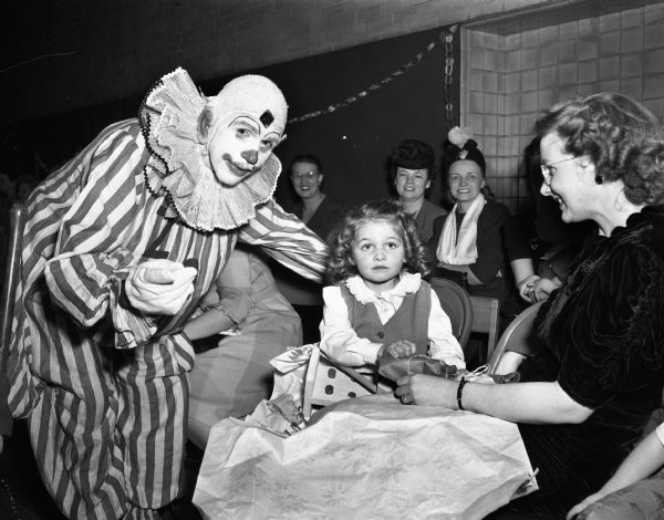 A Shrine clown pointing out Santa Claus to a young girl at the Madison Shriners yule party at the Washington Orthopedic School, 545 West Dayton Street.