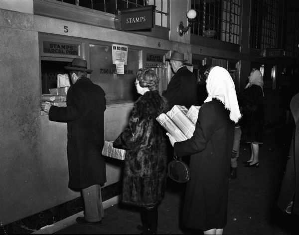 People with packages lined up at the customer service windows of the Madison post office, 215 Monona Avenue, at Christmas.