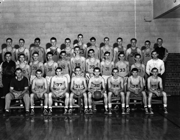 Group portrait of the Edgewood High School boys basketball team in uniform with their coach Earl Wilke.