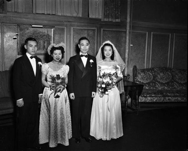 University of Wisconsin graduate students from China, bride Shu-Teh Cheng, Nanking, China, and bridegroom Shu-Chin Yang, Faku, China. The couple had an American style wedding at First Congregational Church, 1609 University Avenue. Standing to the left of the bridal couple are their attendants Mr. Fung-Haan Fung, and Miss Man-Teh Hau.