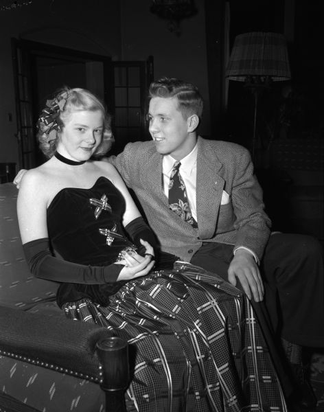 Rose Marie Licht and Jack Olds posing on a couch at the Masonic Temple. They are attending the annual Order of DeMolay holiday ball.