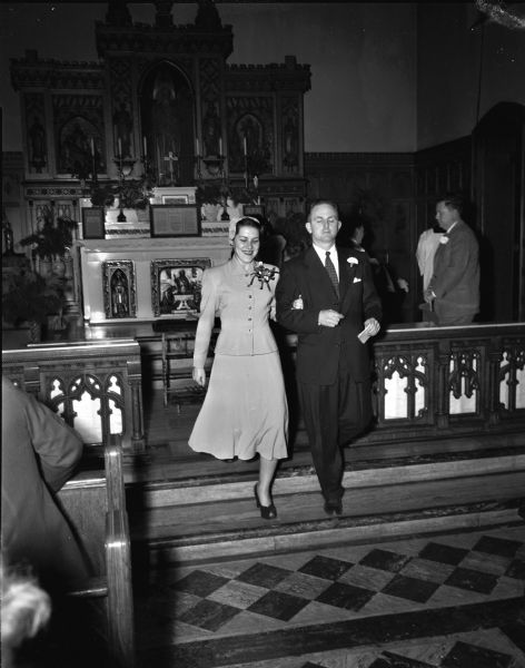 John L. McGuire and his bride, the former Patricia A. Podjaski, leaving the altar at St. Paul's University Chapel following their wedding. Pictured at left are witnesses Merrill Haley and Cornella Podjaski.