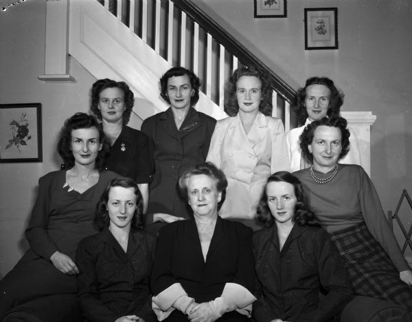 Mrs. Thomas B. (Margaret) Coughlin, 510 West Shore Drive, and her eight daughters who are home for the Christmas season with their families. Seated are: Mrs. William (Virginia) Earl, Lamont, Illinois; Nancy Coughlin (Johnson); Mrs. Margaret Coughlin; Patricia Coughlin (Landowski), Nancy's twin; Mrs Glen (Gene, Genevive) Marty. Second row, left to right: Mrs. Richard (Phyllis) Mueller; Mrs. Vernon L. (Norma) Hastings, Lincoln, Nebraska; Mrs. Robert (Betty) Oakey; and Mrs. George (Caryol) Oscar, Dayton, Ohio.
