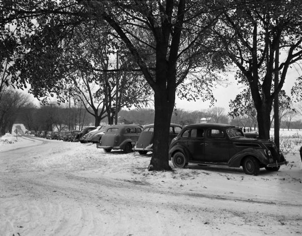 Cars parked illegally on Farwell Drive in Maple Bluff. Cars belong to people ice fishing on Lake Mendota. A traffic problem was created in the village of Maple Bluff during the weekend when hundreds of persons from all parts of southern Wisconsin descended on Lake Mendota to fish through the ice for perch and other pan fish.