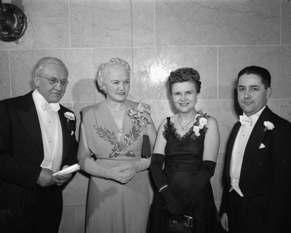 Group portrait, left to right: Governor Oscar Rennebohm and Mrs. Mary Rennebohm and Mrs. John (Leona) Sonderegger, and State Treasurer John Sonderegger. The couples are attending the Wisconsin Centennial Ball at the Wisconsin State Capitol.