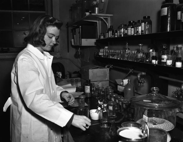 A woman in a laboratory coat working in a laboratory. (Possibily Jane Fred?).