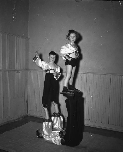 Two children and one adult in a gymnastic pose at Madison's Turner Hall, 21 South Butler Street.