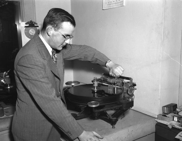 Robert Wickhen, recording engineer, is cutting a recording at WHA Radio Station.