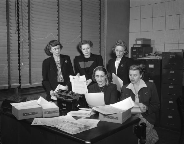 Members of the Madison Junior Chamber of Commerce auxiliary, "Jaycettes,"  addressing 3000 letters to be mailed to Dane County residents as part of a fund drive for a permanent Wisconsin cerebral palsy hospital. Pictured standing left to right: Mrs. I.C.(Ruth) Prafke, publicity; Mrs. A.I. (Marcella) Negus, Jr., Madison Jaycettes president, and Mrs. G.E. (Evelyn) Hansen, fund committee member. Seated left to right: Mrs. P.A. (Anna) Cary, county chairman of the drive, and Mrs. M.V. ( Lucille) Bump, state chairman of the drive.