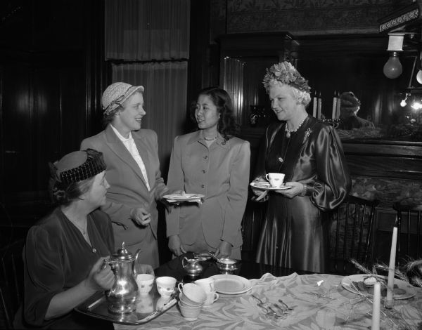 Shown at the American Association of University Women (AAUW) tea from the left are: Mrs. Merritt Y. (Grace) Hughes; Mrs. William A. Werrell; Miss Tasanee Isarasena; and Mrs. Oscar (Mary) Rennebohm, wife of the governor.  Miss Isarasena is a graduate student from Bangkok, Siam, on an AAUW fellowship.