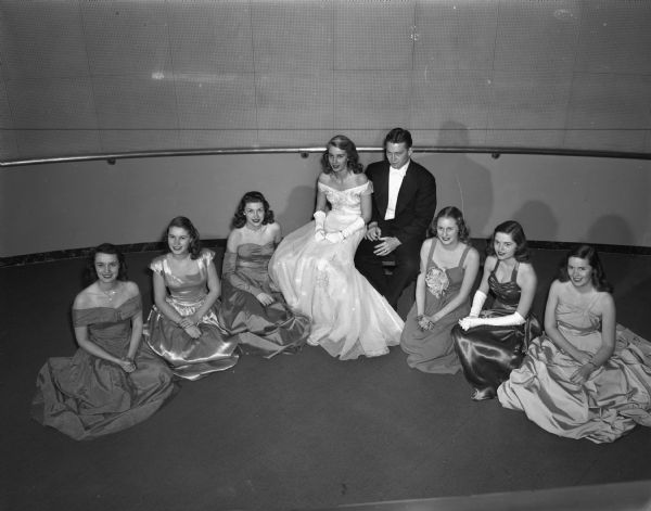 The king and queen of the University of Wisconsin-Madison junior prom with the six co-eds named as "Badger Beauties".  Left to right are: Marilyn Henry, Waukegan, Illinois; Mary Schneiders, San Diego, California; Lois Johnson, Marshfield; queen Eugenia Tuhtar, Janesville; king James Lawrence, Tulsa, Oklahoma; Nancy Olmsted, Oshkosh; Nancy Hanschman, Wauwatosa; and Jean Bieler, Western Springs, Illinois.