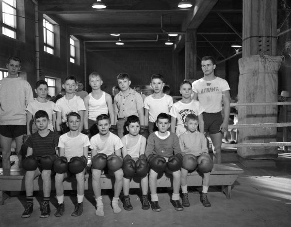 Group portrait of 12 boys enrolled in the 11 o'clock boxing class held at the University of Wisconsin boxing quarters on Saturday mornings with two instructors.