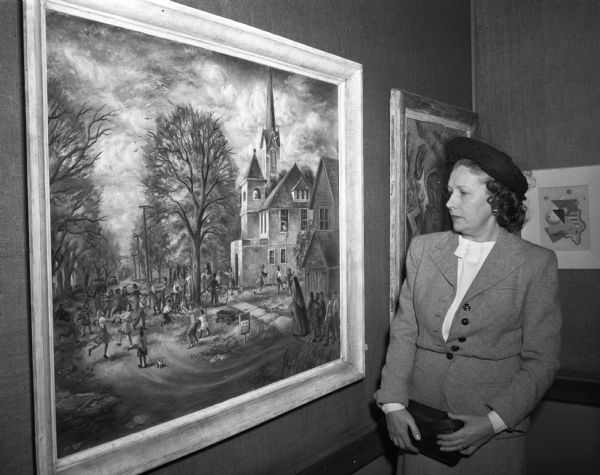 Mrs. A.C. (Eugenia) Bolz looking at the painting "Recess" by Lois Ireland which won the Oscar F. Mayer purchase prize in the Madison Artists Exhibition. Mrs. Bolz is the daughter of Oscar F. Mayer.