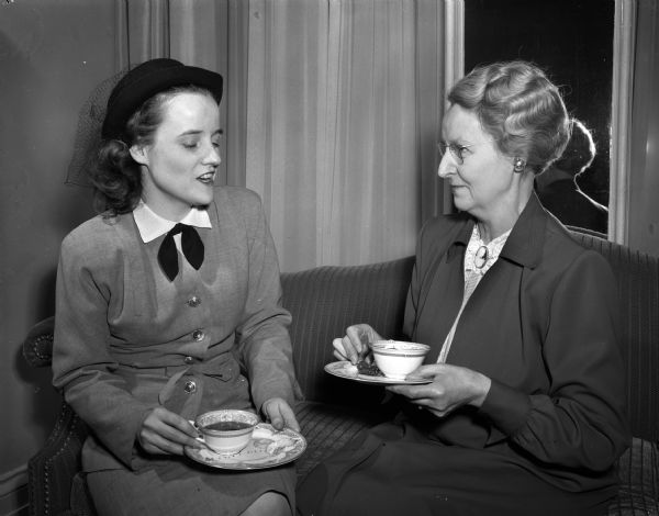 Elizabeth Davies (left), Baraboo, president of the Wisconsin Home Agents' association, talking to Mary Baldwin, wife of the Dean of the University of Wisconsin College of Agriculture, at a tea at the executive residence as part of the University of Wisconsin Farm and Home Week activities.