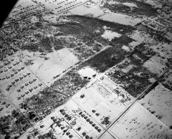 Aerial photograph looking northwest across the reservoir on Glenway Street. Featured are Hoyt and Quarry Parks, Resurrection Cemetery. Major streets are Franklin Street, Regent Street, and Bluff Street. There is snow on the ground.