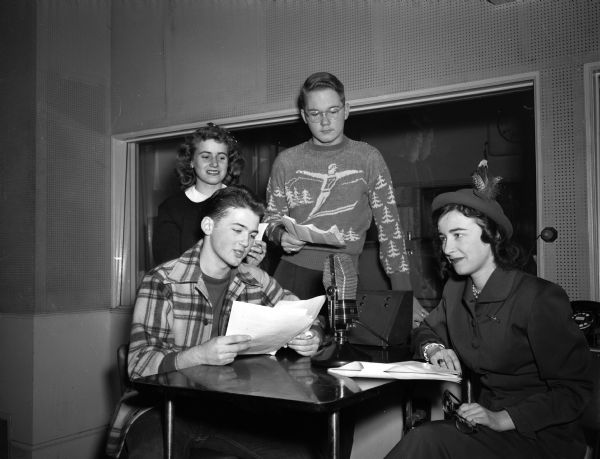 Betty Booth, associate editor of <i>Seventeen</i> magazine, being interviewed by Madison high school students on the Madison Youth Radio Workshop program broadcast over WIBA.  Standing left to right: Mary Jensen, West High and Bob Edlund, East High. Seated are Dave Madson, West High, and Betty Booth.