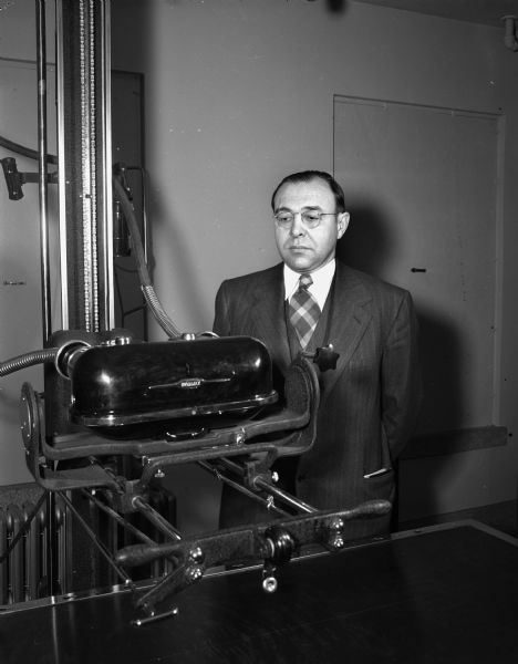 Dr. Walter Urben, superintendent of Mendota State Hospital, shown examining an X-ray machine that is part of the equipment of the Veterans Administration hospital at Mendota.  The Veterans' hospital was to be operated as part of the Mendota hospital as of July 1. (Mendota Mental Health Institute)