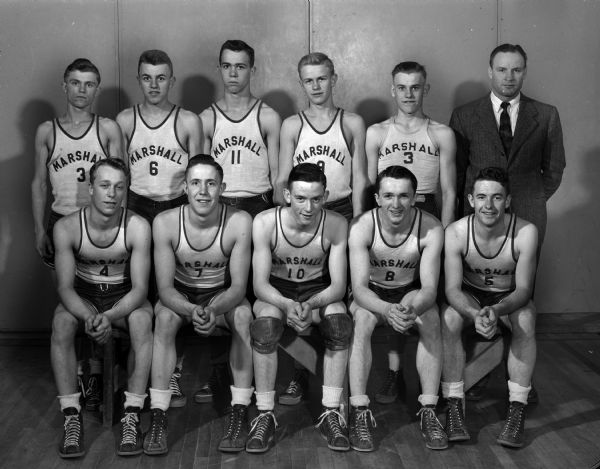 Group portrait of ten members of the Marshall High School basketball team and the team coach.