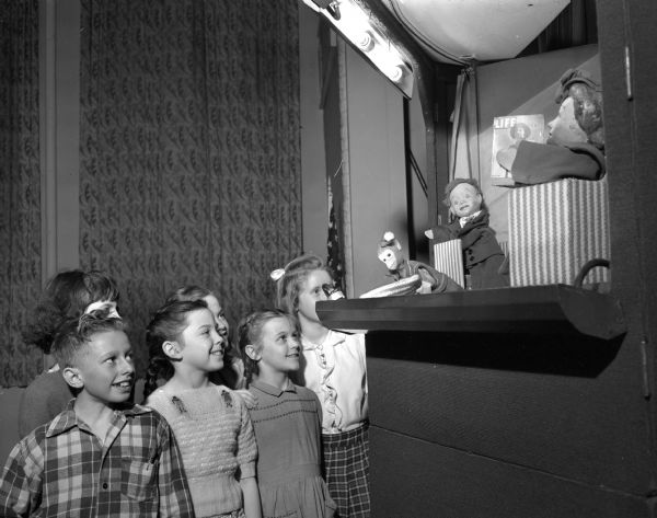 Six Emerson elementary school children at a puppet show promoting good teeth care.  The children, from left to right are, first row: Ronald Gamer, Nancy Forbes, and Patsy Chamberlain; second row: Lee Ray Simplot, Nancy Gafke, and Hanet Moran.