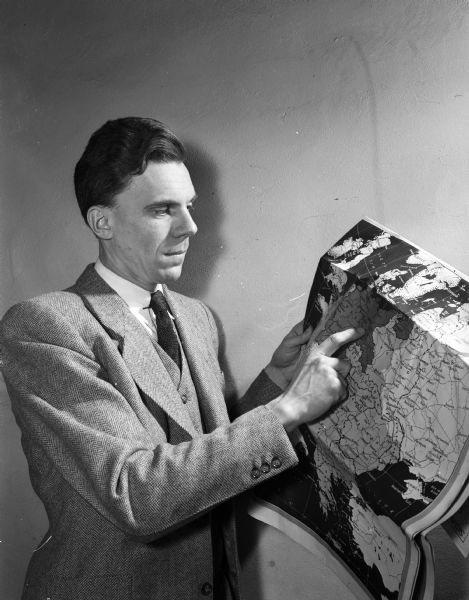 The Rev. James C. Flint, former minister to the Congregational students at the University of Wisconsin, pointing to a map of Europe as part of a lecture about post World War II relief work overseas.