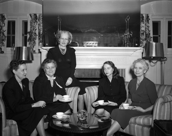Shown are five members of the University of Wisconsin chapter of the Alpha Gamma Delta sorority in the drawing room of the chapter house at 220 Lake Lawn Place. The women are making arrangements for a fund-raising bridge party which will benefit children afflicted with cerebral palsy.