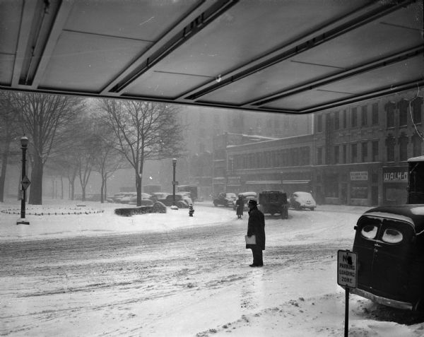 View of the Capitol Square during the year's record snowstorm, taken from under the canopy of the Park Hotel showing the corner of South Carroll and West Main Street.