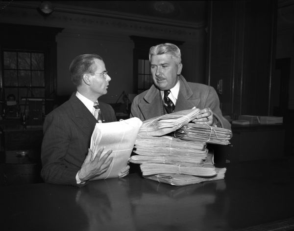Victor Johnston (right) state manager of the Stassen-for-President campaign presenting nomination papers for fifteen of the Republican National Convention Stassen pledged delegate candidates seeking election in the primary election. Accepting the papers (left) is Gaige Roberts, chief of the Elections Division.