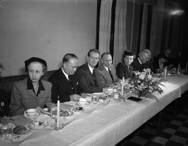 YMCA twenty-ninth anniversary dinner meeting. Seated at the head table are: left to right, Mrs. A.F. (Madelyn) Trebilcock; Arthur Trebilcock, president of the Board of Directors; Orman Moulton, Secretary for the International Committee of the YMCA in Greece, the main speaker; toastmaster Clarence J. Burrowbridge and his wife Ruth; 
Frederick O. Leiser, first Madison YWCA General Secretary; attorney Emerson Ela, first president of the Madison YMCA Board of Directors.