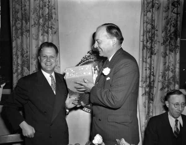 Harold E. Stassen (center), in Monroe, receiving a block of cheese from District Attorney Rudolph P. Regez.