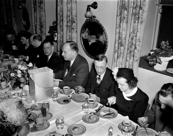Harold E. Stassen at the speaker's table at a campaign luncheon in Monroe. Seated (left to right) are: Mrs. R.L. Rote, Rev. E.C. McCollow, District Attorney Rudolph P. Regez, Stassen, Monroe Mayor Frank A. Buehler, and Mrs. William Thurber. A large block of cheese sits on the table.