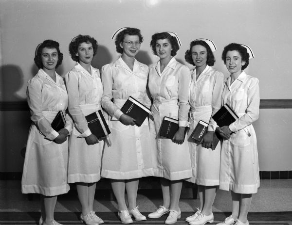 Group portrait of six graduates of St. Mary's school of nursing posing in their uniforms. Pictured from left to right are: Marguerite Hotz, Sheboygan; Donna Thompson, McFarland; Genvieve Dolan, Avoca; Suzanne Rippchen, Stoughton; Gertrude Deery, Darlington.