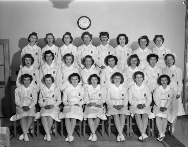 Group portrait of 23 pre-clinical nursing students at St. Mary's school of nursing who have just received their white caps after completing their six months probation period.
