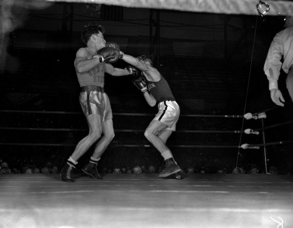 NCAA boxing tournament at University of Wisconsin-Madison. Bob Apperson, Wisconsin, is throwing a straight left to Cayocca's head, San Jose State, in the third round.