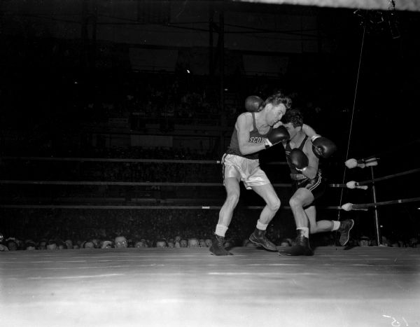 University of Wisconsin boxer Bob Apperson, left, missing with a left punch to University of Maryland boxer Andy Quattroccki who is missing with a right punch. The two men are participating in a lightweight bout in the NCAA championship being held at the University of Wisconsin-Madison Field House. Apperson won the bout and the lightweight championship.