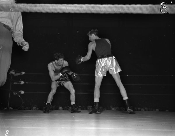 Wisconsin's Steve Gremban with a left hand cocked and ready in the second round while Louisiana State's Wilbur Moss looks sharply for an opening. The two men are participating in the bantamweight category NCAA championship being held at the University of Wisconsin-Madison Field House.