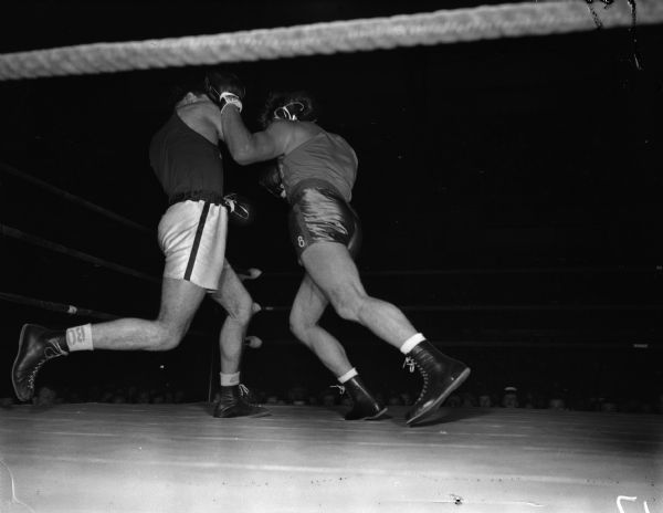 In the first round Wisconsin's Vito Parisi threw a right hand inside a left hook by Miami's Art Saey during their heavyweight bout. The two men are participating in the NCAA championship being held at the University of Wisconsin-Madison Field House.