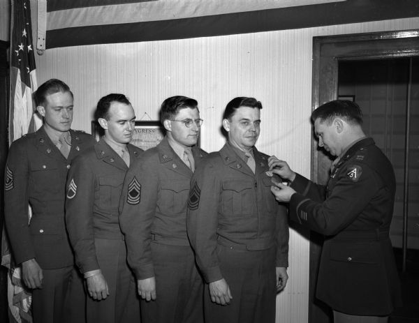 Receiving the American Campaign Medal from Capt. Vincent S. Dilly are First Sgt. Melvin Miller, Staff Sgt. John Ludden, Master Sgts. James Wolff and Olaf Roe. Sgt. Wolff was also awarded the Asiatic-Pacific campaign medal.